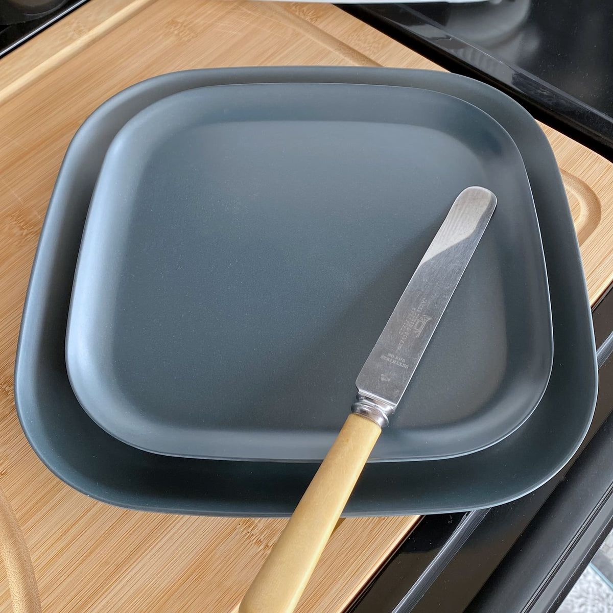bamboo plates 22cm and 26cm with knife, midnight grey, on caravan table