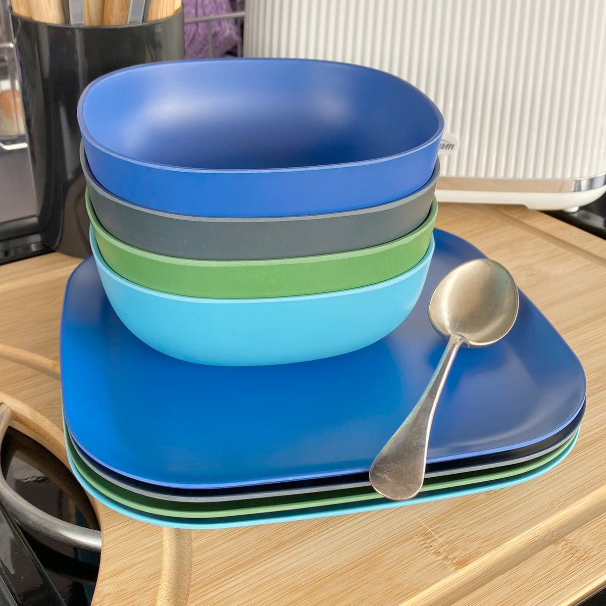4 piece bamboo cereal bowl set, coastal mix in classic green, midnight grey, pale blue and sea blue, stacked with plates