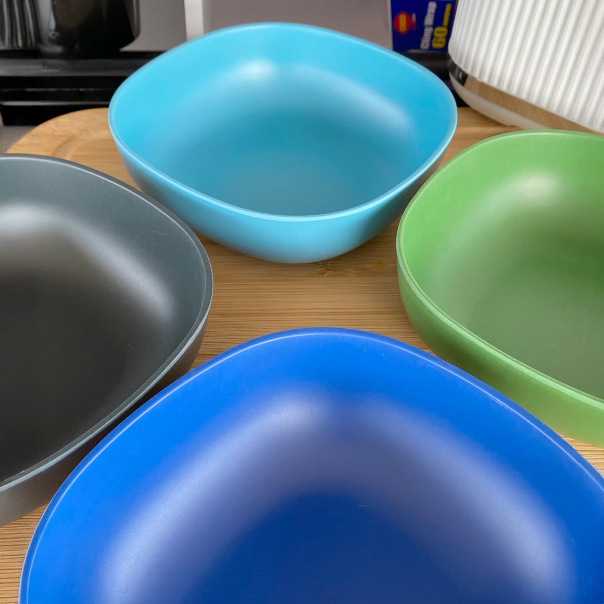4 piece bamboo cereal bowl set, high country mix in classic green, sea blue, pale blue and midnight grey, laid flat on table
