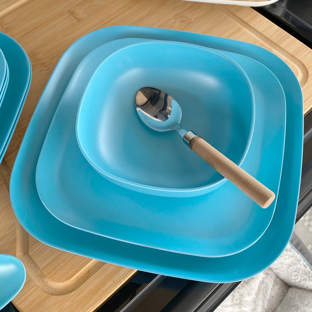 bamboo cereal bowl 15cm, 22cm and 26cm plates, in pale blue with spoon in bowl