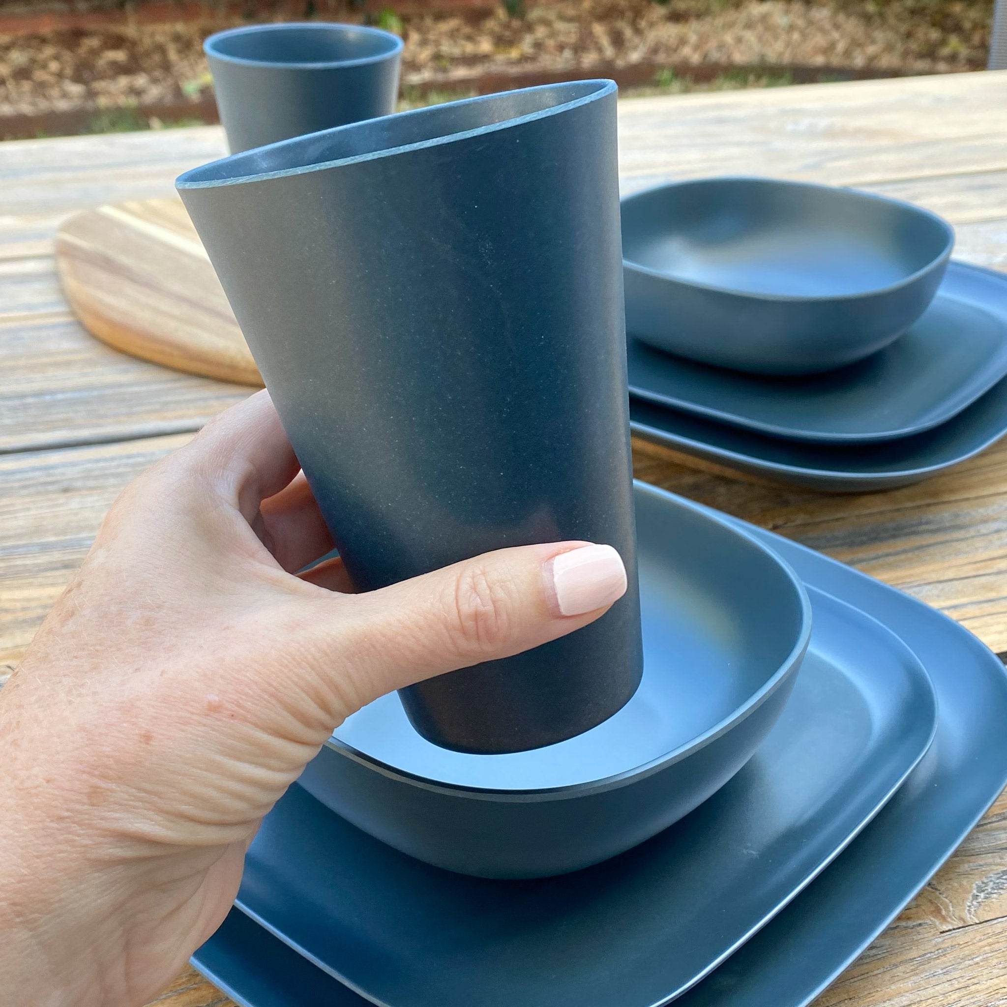 Van Go Caravan and camping 8 piece bamboo dinnerware set in classic midnight grey including camping plates, bowl and tumbler. Closeup of tumbler on timber table