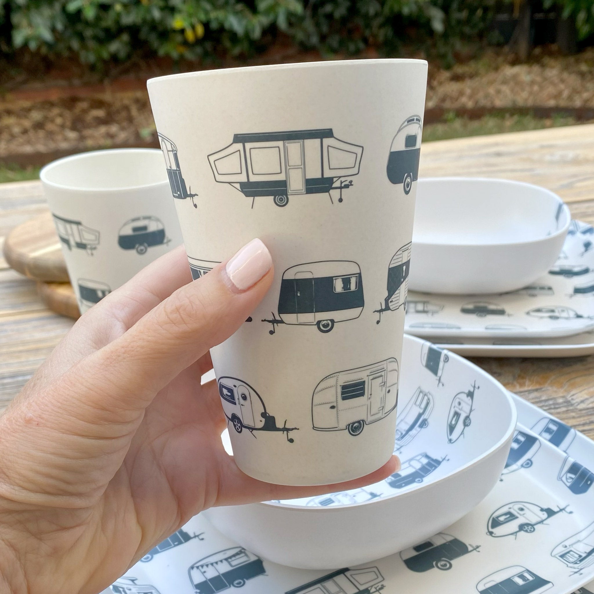 Van Go Caravan and camping 8 piece bamboo dinnerware set in destination collection with midnight grey caravan print including camping plates, bowls and tumblers plus tumbler closeup on timber table