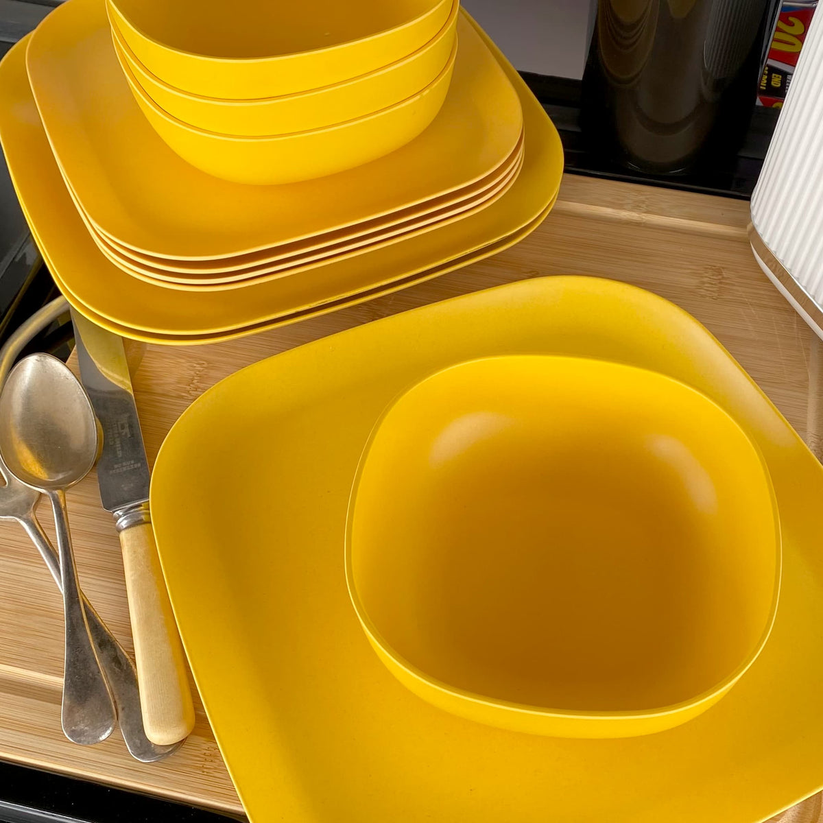 4 piece bamboo cereal bowl set, 22cm and 26cm plate sets, in sunshine yellow, stacked and flat
