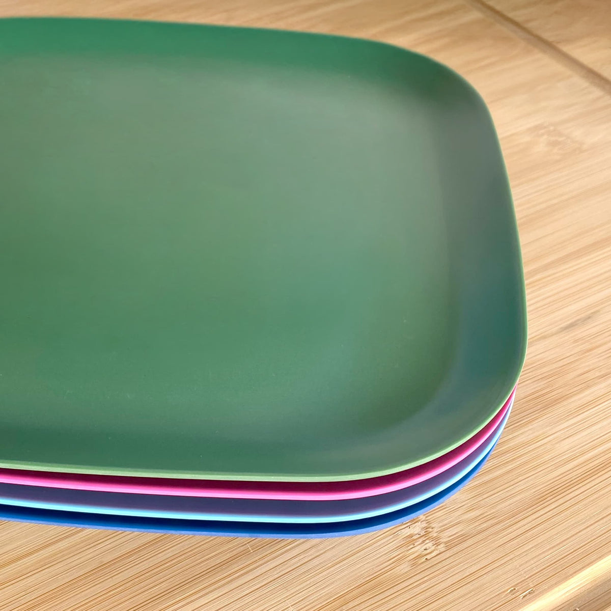 4 piece bamboo plate set 22cm, coastal mix in classic green, vintage pink, pale blue, sea blue, stacked showing curved edge
