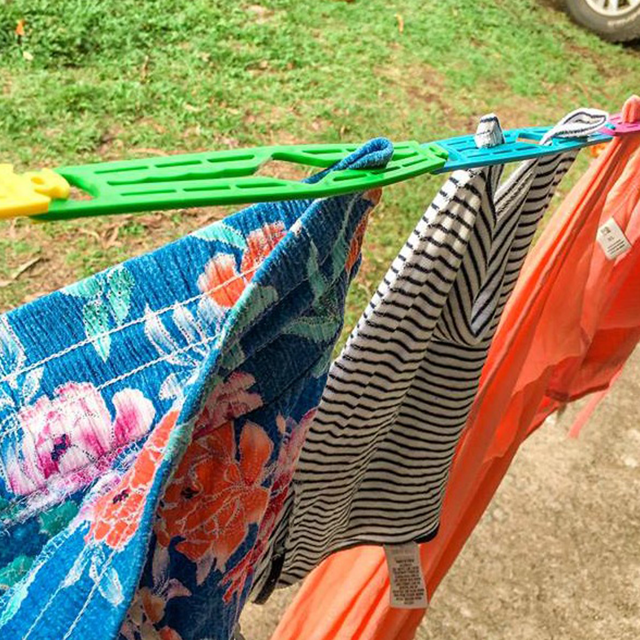 Close-up of Slide n' Dry rainbow pegless clothesline slides clicked together showing clothes in gripping slots