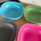 4 piece bamboo cereal bowl set, bush mix in classic green, vintage pink, pale blue and midnight grey, laid flat on table
