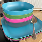 4 piece bamboo cereal bowl set, bush mix in classic green, vintage pink, pale blue and midnight grey, stacked with plates
