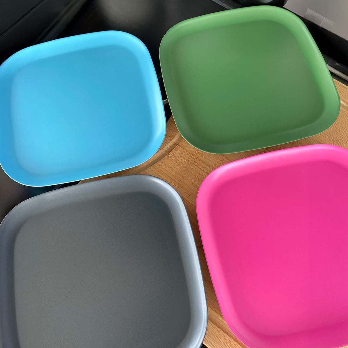 4 piece bamboo plate set 22cm, bush mix in classic green, vintage pink, pale blue and midnight grey on timber board