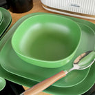 bamboo cereal bowl 15cm on 22cm and 26cm plates in classic green, iconic collection, close-up with spoon