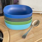 4 piece bamboo cereal bowl set, high country mix in classic green, midnight grey, pale blue and sea blue, on table with spoon