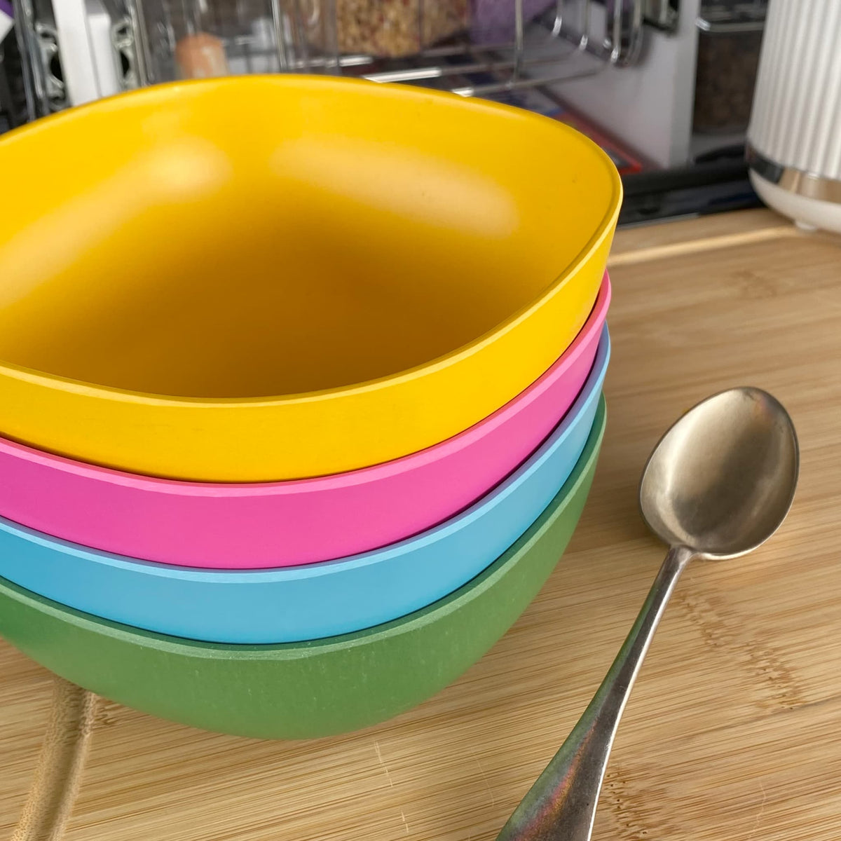 4 piece bamboo cereal bowl set, coastal mix in classic green, vintage pink, pale blue and sunshine yellow, stacked with spoon