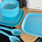 4 piece bamboo cereal bowl set, 22cm plate set and 26cm plate set in pale blue, stacked and flat with servers