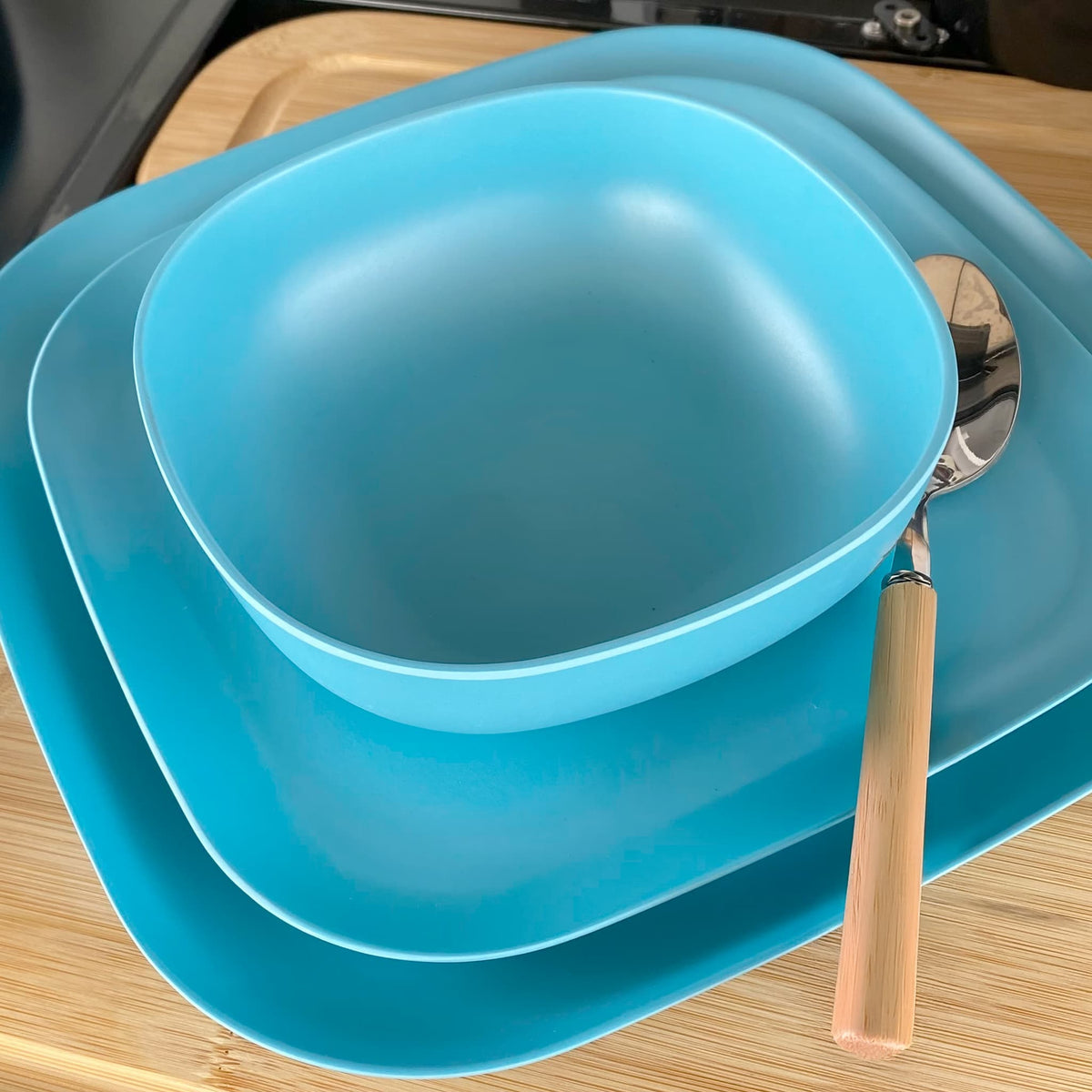 bamboo bowl, plate 22cm and 26cm in pale blue, on table with spoon
