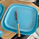bamboo plate 22cm on 26cm in pale blue, on table with knife