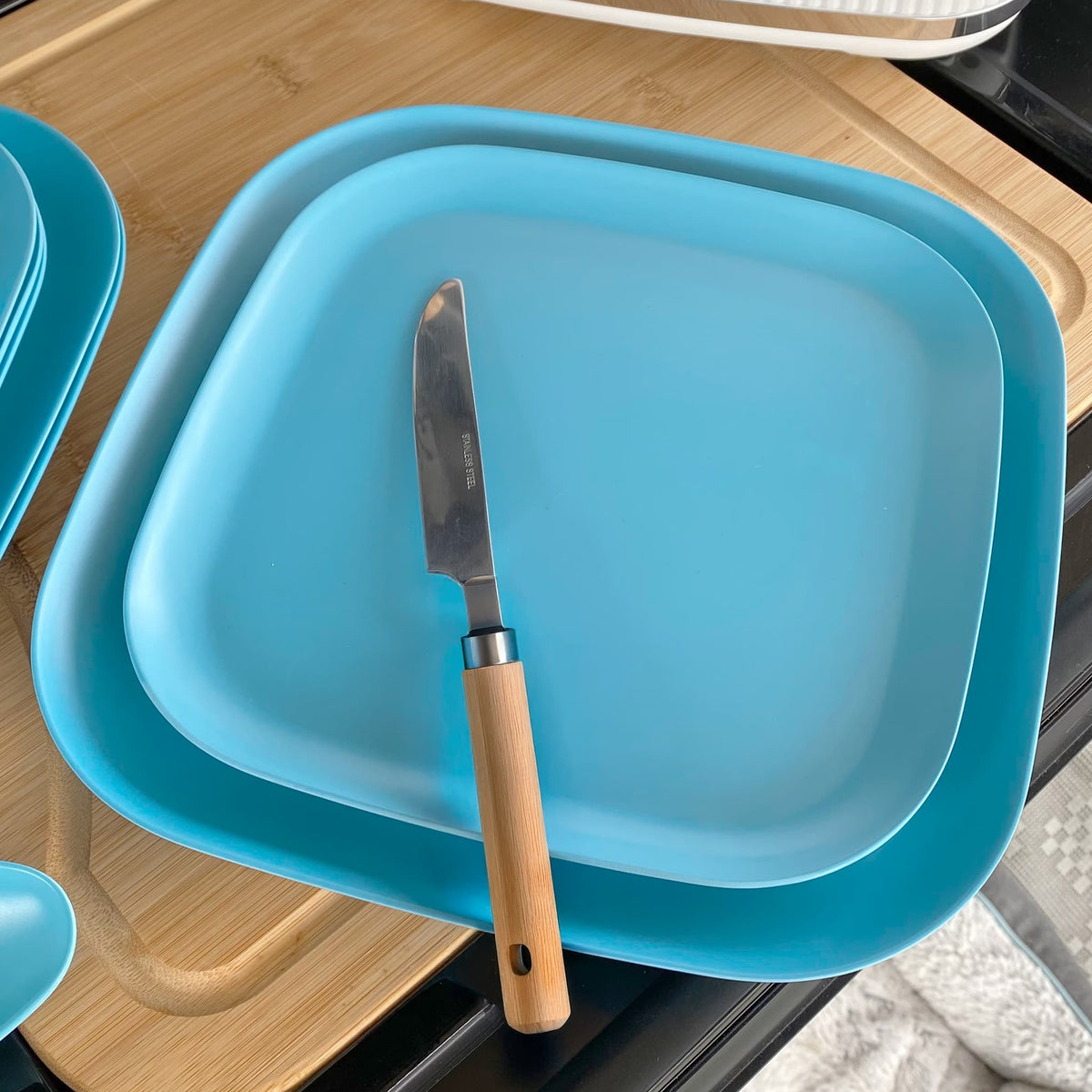 bamboo plate 22cm on 26cm in pale blue, on table with knife