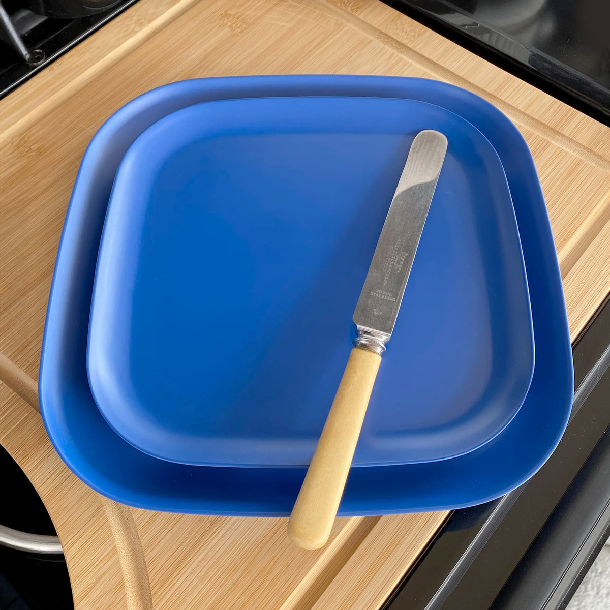 bamboo plate 22cm on 26cm in sea blue, on table with knife