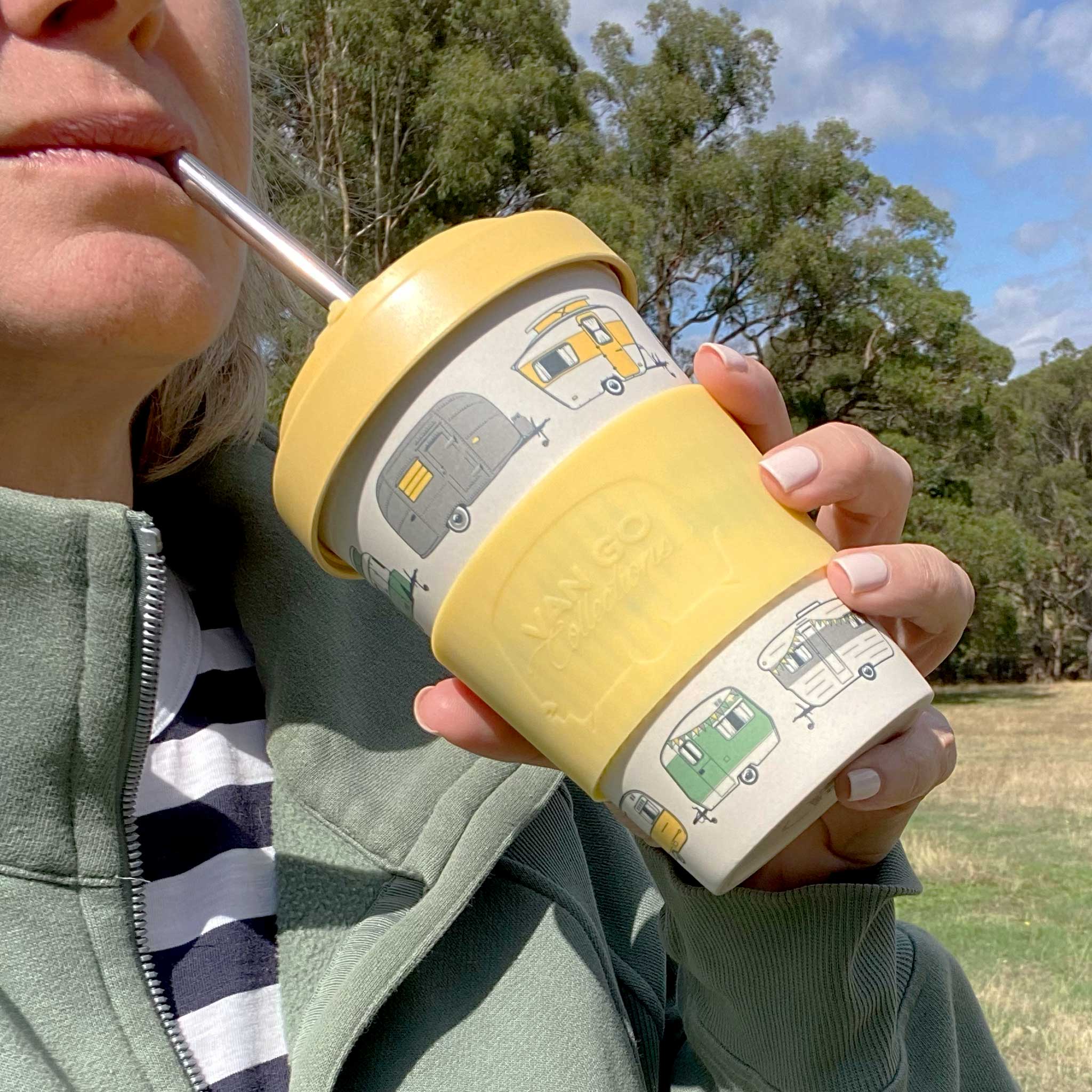 Van Go Bamboo Travel Mug 400ml, iconic caravan design sunshine yellow BPA free reusable keep cup with straw in persons hand