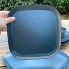 Van Go Caravan and camping 8 piece bamboo dinnerware set in classic midnight grey showing camping plate in hand