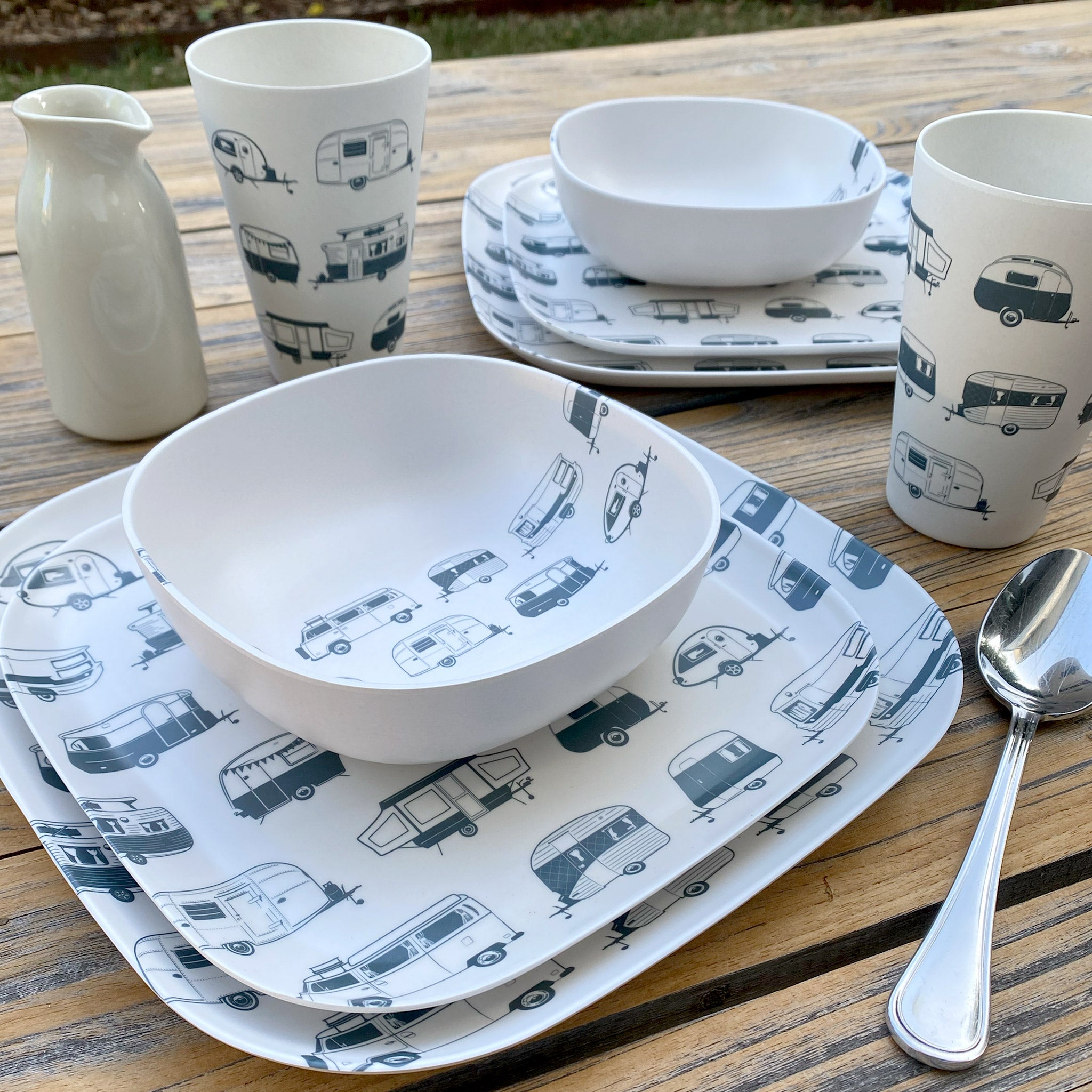 Van Go Caravan and camping 8 piece bamboo dinnerware set in destination collection with midnight grey caravan print including camping plates, bowls and tumblers on timber table with spoon and jug