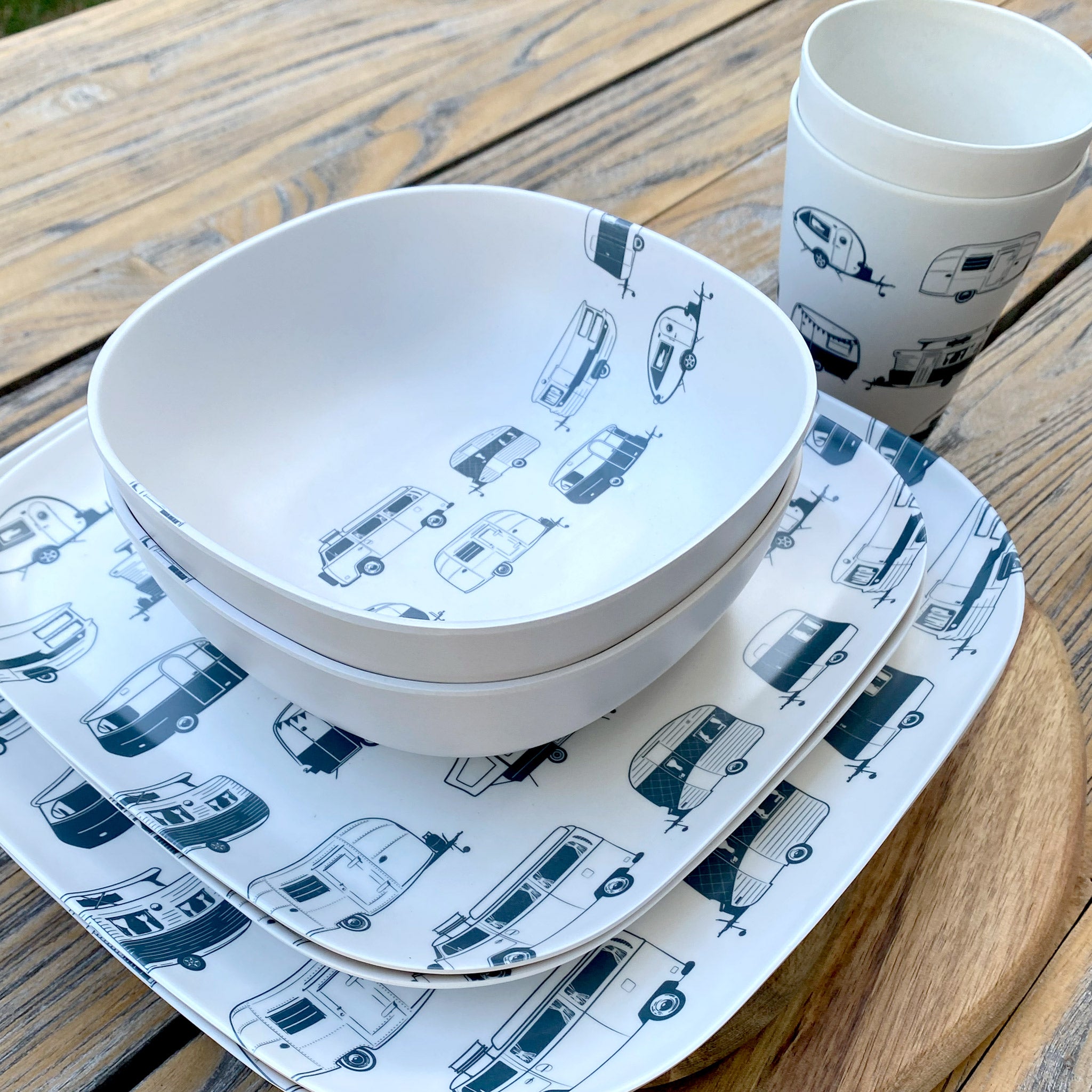 Van Go Caravan and camping 8 piece bamboo dinnerware set in destination collection with midnight grey caravan print including camping plates, bowls and tumblers stacked on timber table