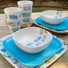 Van Go Caravan and camping 8 piece bamboo dinnerware set Camper plate, bowl and tumblers plus pale sky blue plate on timber table and boards