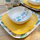 Van Go Caravan and camping 8 piece bamboo dinnerware set Camper plate, bowl and tumblers plus sunshine yellow plate closeup on timber table