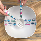 Van Go Bamboo Salad Bowl and Servers Set coloured caravans Iconic collection salad bowl with matching salad servers in hands displayed on timber board and table, birds eye view.