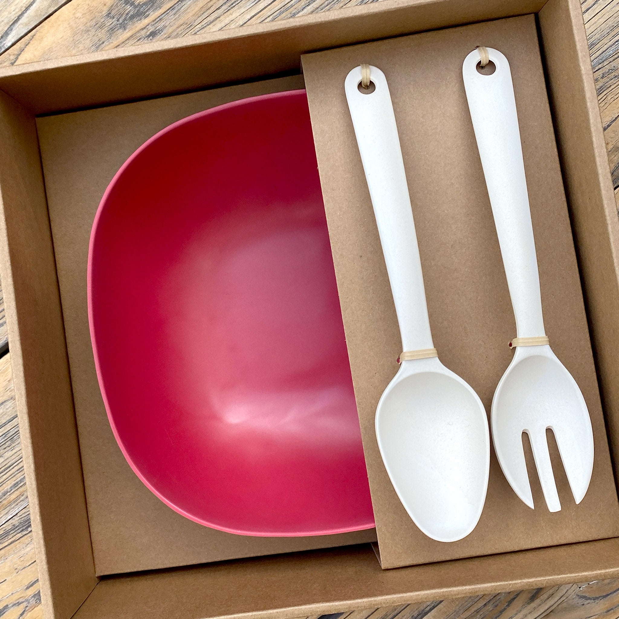 Van Go Bamboo Salad Bowl and Servers Set red salad bowl with natural salad servers displayed in brown gift box on timber table
