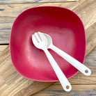 Van Go Bamboo Salad Bowl and Servers Set red salad bowl with natural salad servers displayed on timber board and table