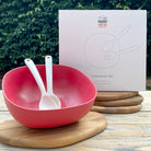 Van Go Bamboo Salad Bowl and Servers Set, red bowl with natural salad servers displayed in front of boxed version on table