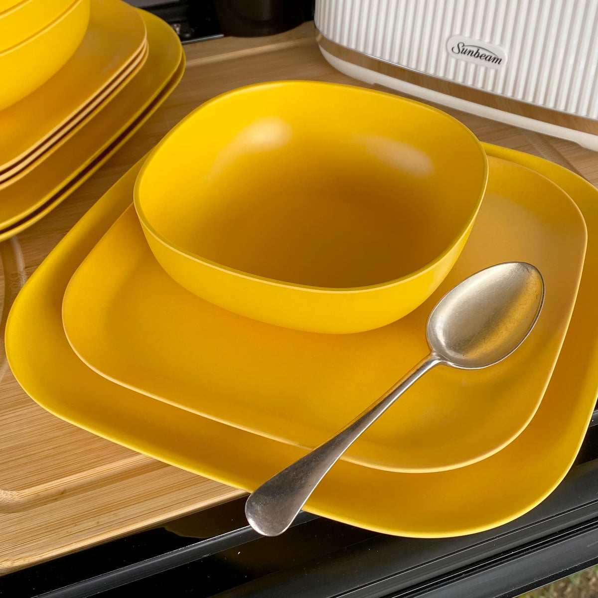 bamboo cereal bowl 15cm in sunshine yellow, on 22cm and 26cm plates with spoon