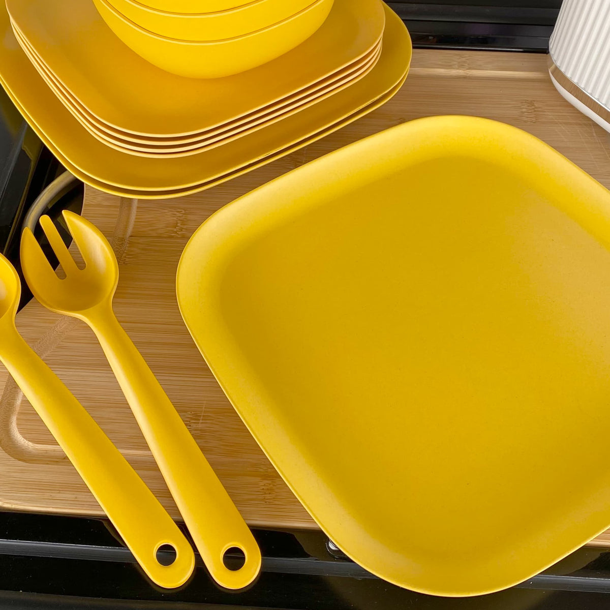 4 piece bamboo cereal bowl set, 22cm plate set and 26cm plate set in sunshine yellow, stacked and flat