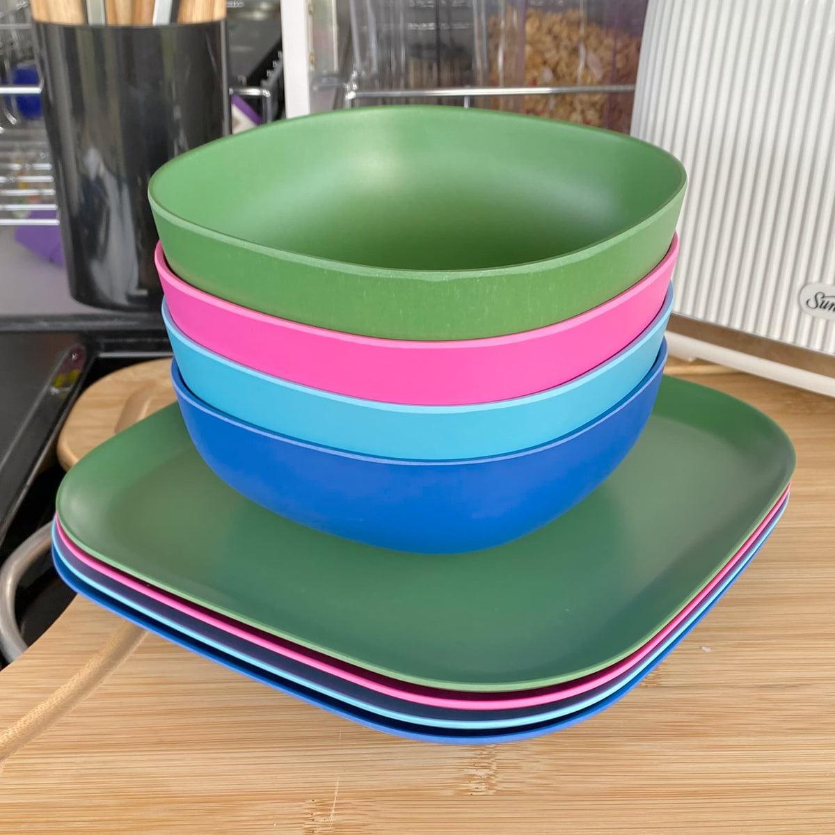 4 piece bamboo cereal bowl set, coastal mix in classic green, vintage pink, pale blue and midnight grey, stacked with plates